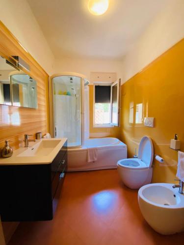 a bathroom with a toilet and a sink and a tub at CASA GARIBALDI 162 in Leverano