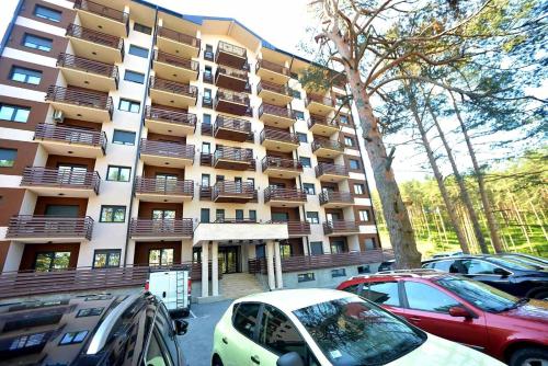 a large building with cars parked in front of it at Lux apartman Zlatibor S14 - vila Peković in Zlatibor