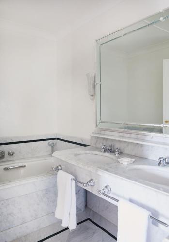 a bathroom with a tub and a sink and a mirror at Grand Hotel Timeo, A Belmond Hotel, Taormina in Taormina