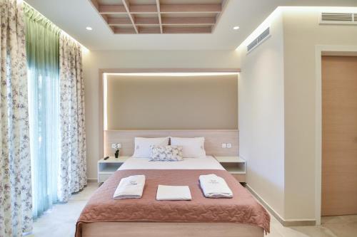 1 dormitorio con 1 cama con 2 toallas en On Board Luxury Studios, en Sarti