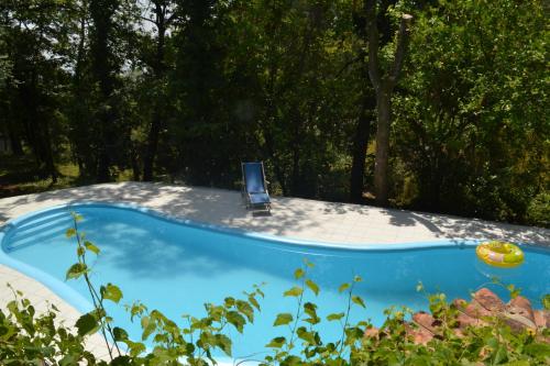a blue pool with a chair in a yard at Quinta Abelha in Três Horas