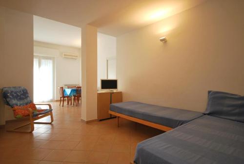 una camera con letto, sedia e televisore di Appartamenti Glicini da Luigi a Finale Ligure
