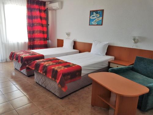 une chambre d'hôtel avec un lit et une chaise dans l'établissement Family Hotel Venera, à Kavarna