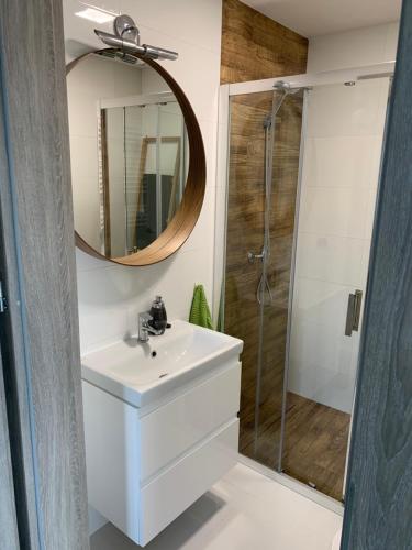 a bathroom with a white sink and a mirror at Apartamenty Wydminy in Wydminy