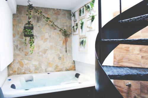 a bath tub in a bathroom with a stone wall at Casa Do Campo in Peniche