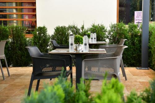 een tafel en stoelen op een terras bij Quartz Boutique Hotel in Mamaia