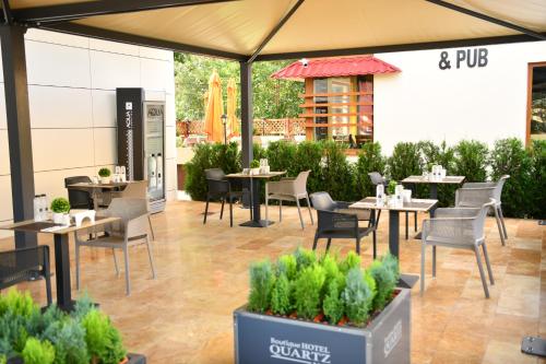 een restaurant met tafels en stoelen en een terras bij Quartz Boutique Hotel in Mamaia