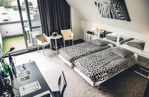pokój hotelowy z 2 łóżkami, stołem i krzesłami w obiekcie Vakantiewoning Hakuna Matata w mieście Geraardsbergen