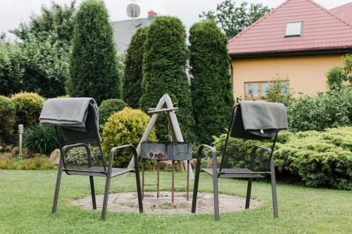 two chairs sitting in the grass in front of a house at Garden Apartment in Cēsis