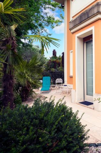 a blue chair sitting on a patio next to a house at La Villa Desenzano in Desenzano del Garda