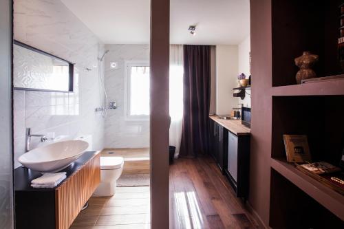 a bathroom with a white sink and a toilet at Facadoro Apartments in Athens