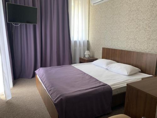 a hotel room with a bed and a flat screen tv at Kozatskiy Hotel in Kyiv