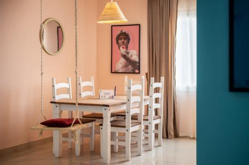 a dining room with a white table and chairs at Two Swings & A Pool - 5 min to Airport in Cairo