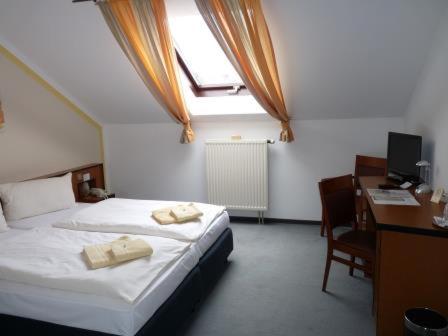 a bedroom with a bed and a desk with a computer at Hotel zur Kanone in Tautenhain