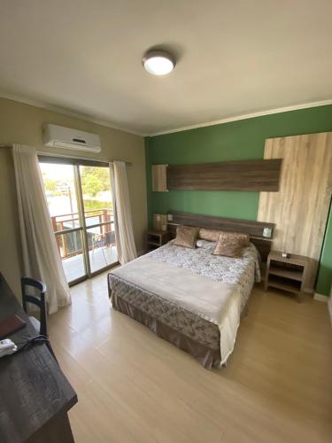a bedroom with a bed and a green wall at SKY VILLE HOTEL GRAMADO - Localização privilegiada entre Gramado e Canela in Gramado