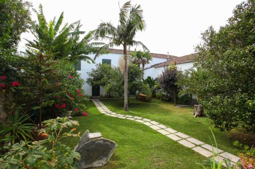 un jardín con una pasarela frente a una casa en Casa do Pico Arde, en Ribeira Grande