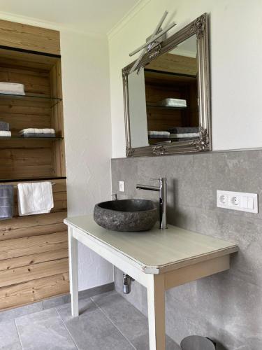 a bathroom with a stone sink on a counter at Ferienwohnung Dolomiten in Nußdorf