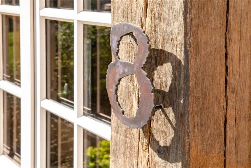 a key on a wooden door with a window at Hôtel Saint-Delis - La Maison du Peintre - Relais & Châteaux in Honfleur