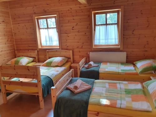 a room with four beds in a log cabin at Bak Vendéglő faházak in Gyulakeszi