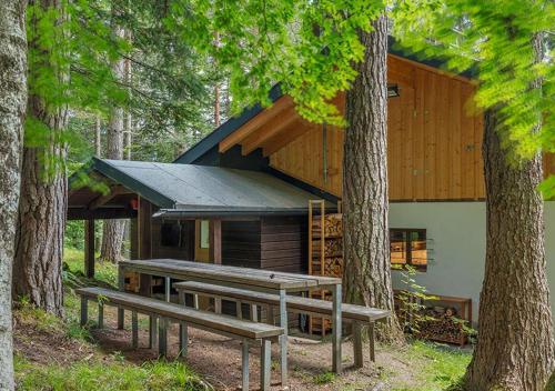 a cabin in the woods with benches in front of it at DAS HAUS IM WALD in Seefeld in Tirol