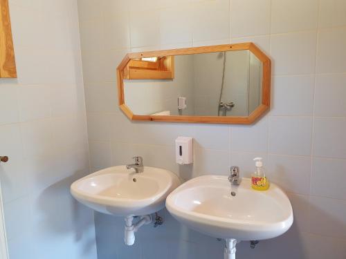 a bathroom with two sinks and a mirror at Bak Vendéglő faházak in Gyulakeszi