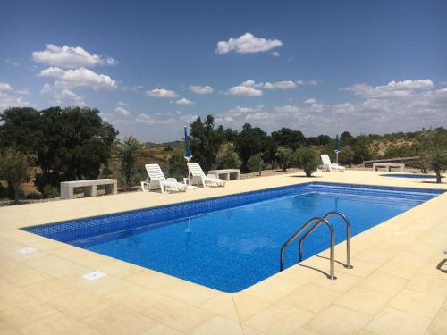 a swimming pool with two chairs at Desafios da Horta in Souto da Velha