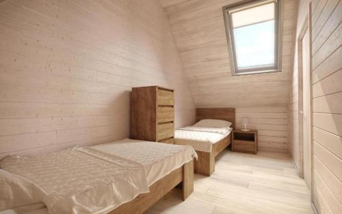 2 łóżka w małym pokoju z oknem w obiekcie Domki OLIVIA w Darłówku