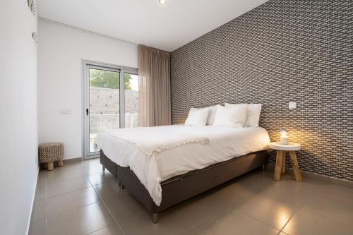 um quarto com uma cama grande e uma parede de tijolos em Private Condominium, Pool, Tennis & Sea View by Silver Prop na Nazaré