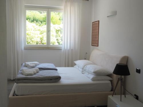a bed in a white room with a window at FairView in Bardolino