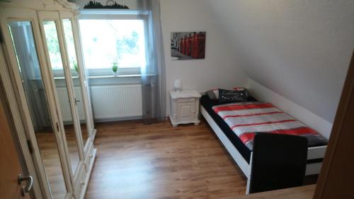 Una pequeña habitación con una cama y una ventana. en Privates Einzelzimmer bei der Weser-Ems-Halle, en Oldenburg