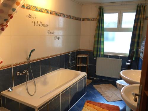 łazienka z wanną i umywalką w obiekcie Ferienwohnung Südpfalzblick w mieście Burrweiler