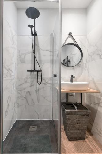 une salle de bain avec une douche avec un lavabo et un miroir dans l'établissement Le Perroquet de La Rochelle, à La Rochelle