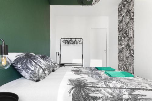 une chambre avec un lit avec une couette noire et blanche dans l'établissement Le Perroquet de La Rochelle, à La Rochelle