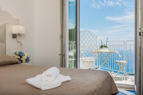 a bedroom with a bed with a view of the ocean at Hotel le Rocce - Agerola, Amalfi Coast in Agerola