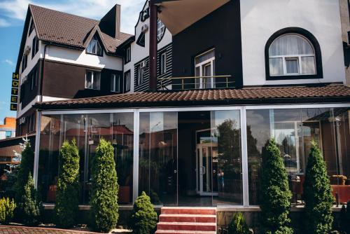 a black and white house with glass windows at Globus Hotel in Ternopilʼ