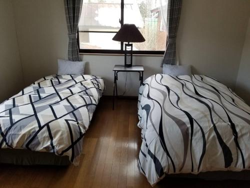 two beds sitting next to each other in a bedroom at C.T.Forest in Oshino