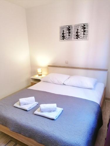 a bedroom with a bed with two towels on it at Apartments Valiža 2 in Senj