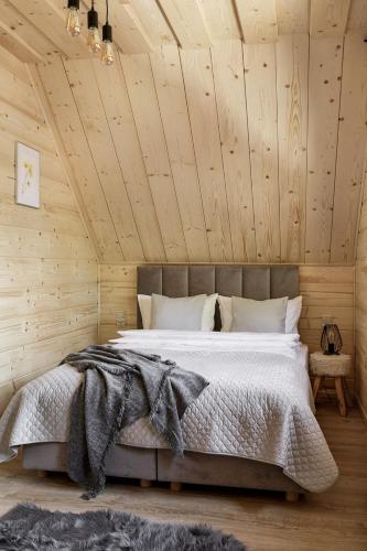 a bedroom with a large bed in a wooden ceiling at Bukowy Raj in Wisła