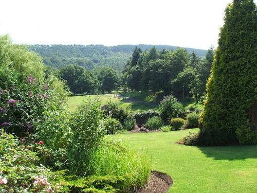 um jardim com relva verde, arbustos e árvores em Ox Pasture Hall Hotel em Scarborough