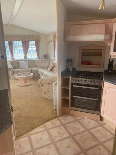 a kitchen with a stove and a living room at Lyndhurst Corner in Dunoon