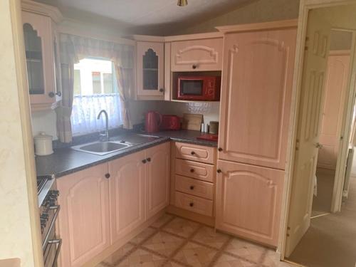 a kitchen with white cabinets and a sink and a window at Lyndhurst Corner 72 in Dunoon