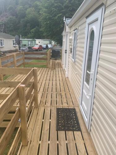 a wooden deck with a door on a house at Lyndhurst Corner 72 in Dunoon