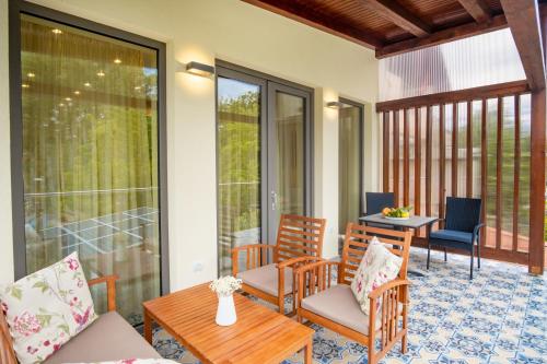 a screened in porch with chairs and a table at Kiss-Henézi Guest House in Keszthely