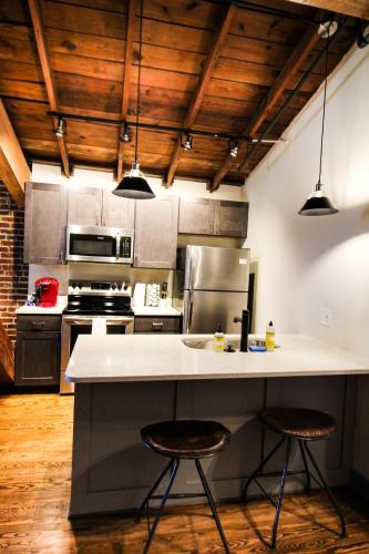 a kitchen with a counter and two stools at The Lofts at Downtown Salem in Salem