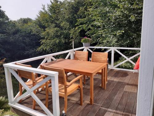 a wooden table and chairs on a deck at Brovst bed and breakfast in Brovst