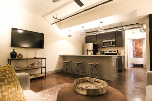 a living room with a kitchen and a bar with stools at The Lofts at Downtown Salem in Salem