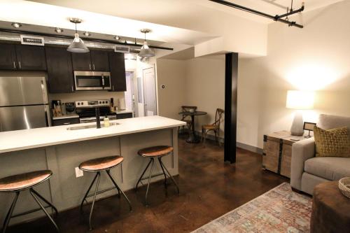 a kitchen and living room with a counter and stools at The Lofts at Downtown Salem in Salem