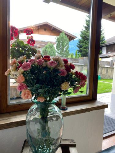 a vase filled with flowers sitting on a window sill at Ferienwohnung Dolomiten in Nußdorf
