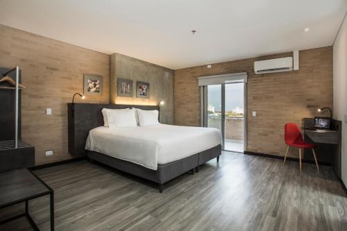 卡利的住宿－Hotel Quinta Norte Chipichape，酒店客房设有一张床和一个大窗户