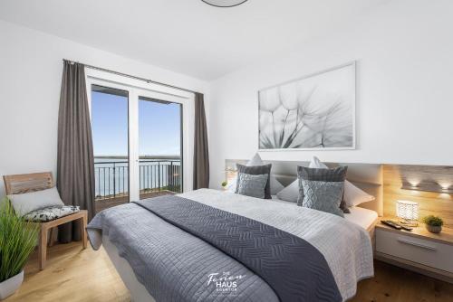 a bedroom with a bed and a large window at Hafenbrise in Olpenitz